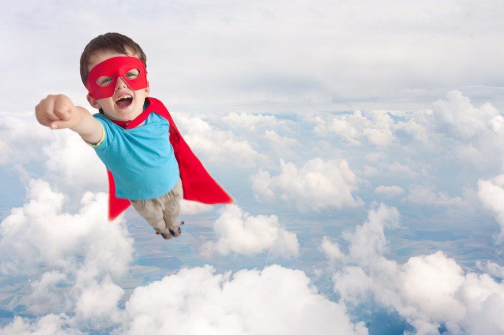 young boy dressed as superhero flying
